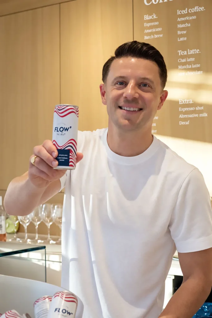 Lachende man met een drankje voor het menubord van THIRD.