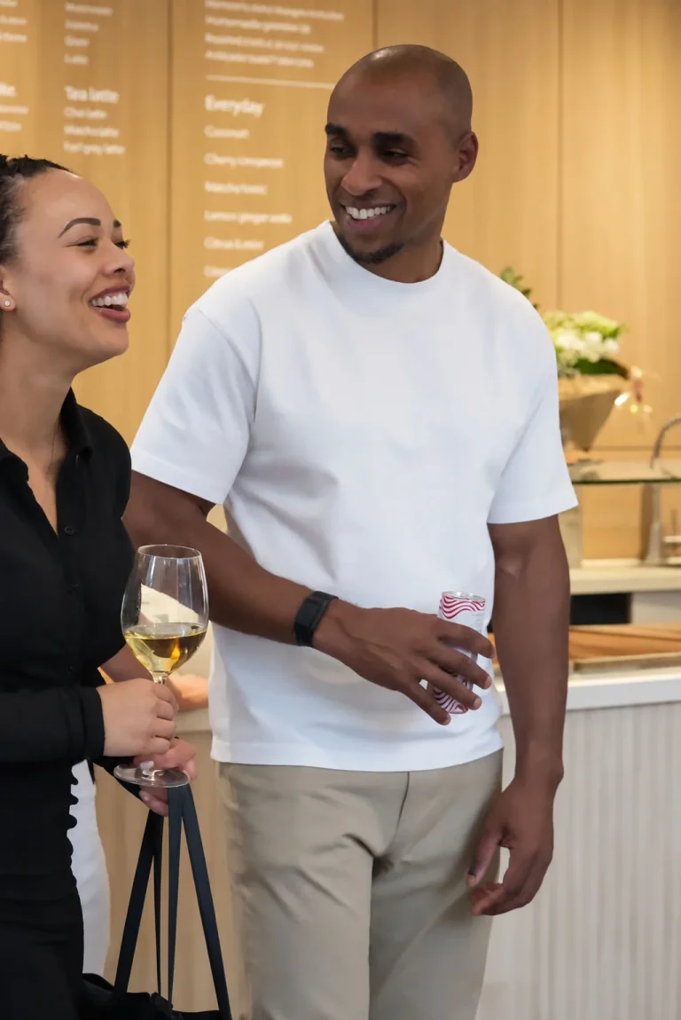 Gasten lachen aan de bar van THIRD., met het menubord op de achtergrond