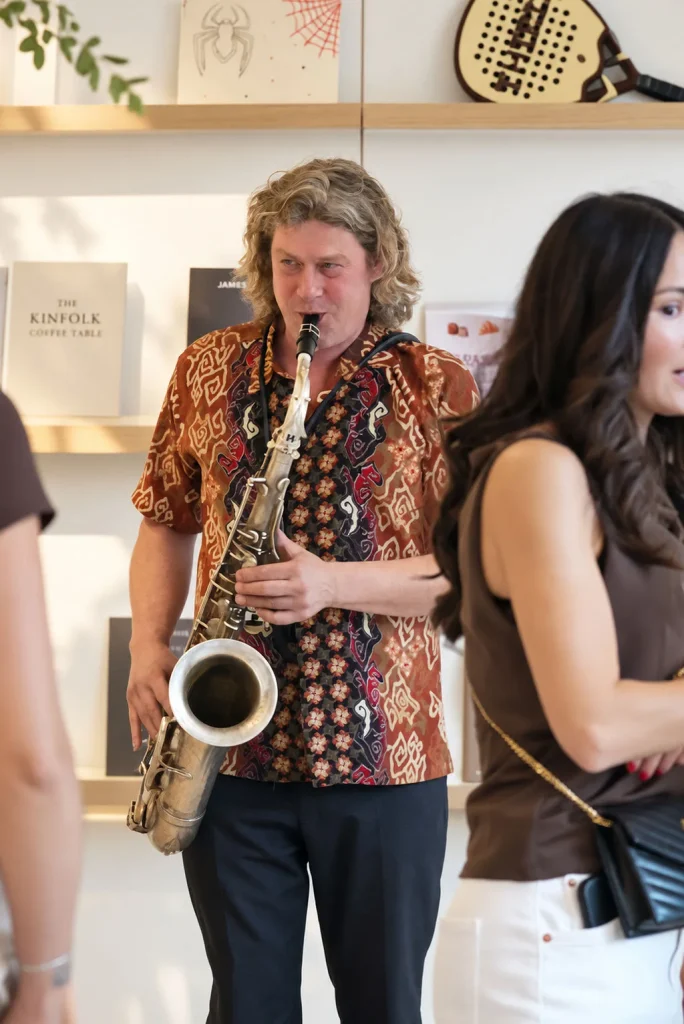 Saxofonist speelt in de zaak bij de houten wandkast van THIRD.