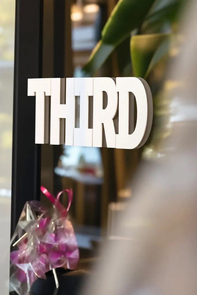 Het THIRD. logo op het raam van de zaak in Amsterdam Zuid