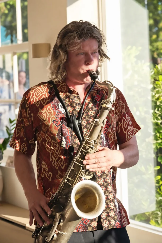 Saxofonist bij het grote raam van THIRD.